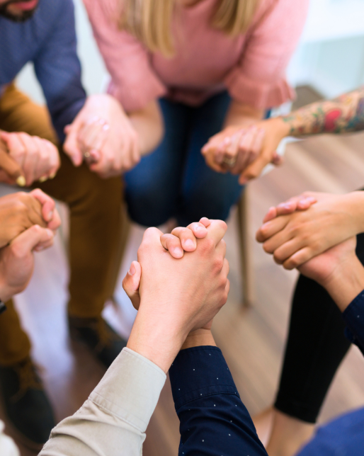 supportive hand holding circle during a recovery meeting for substance use disorder